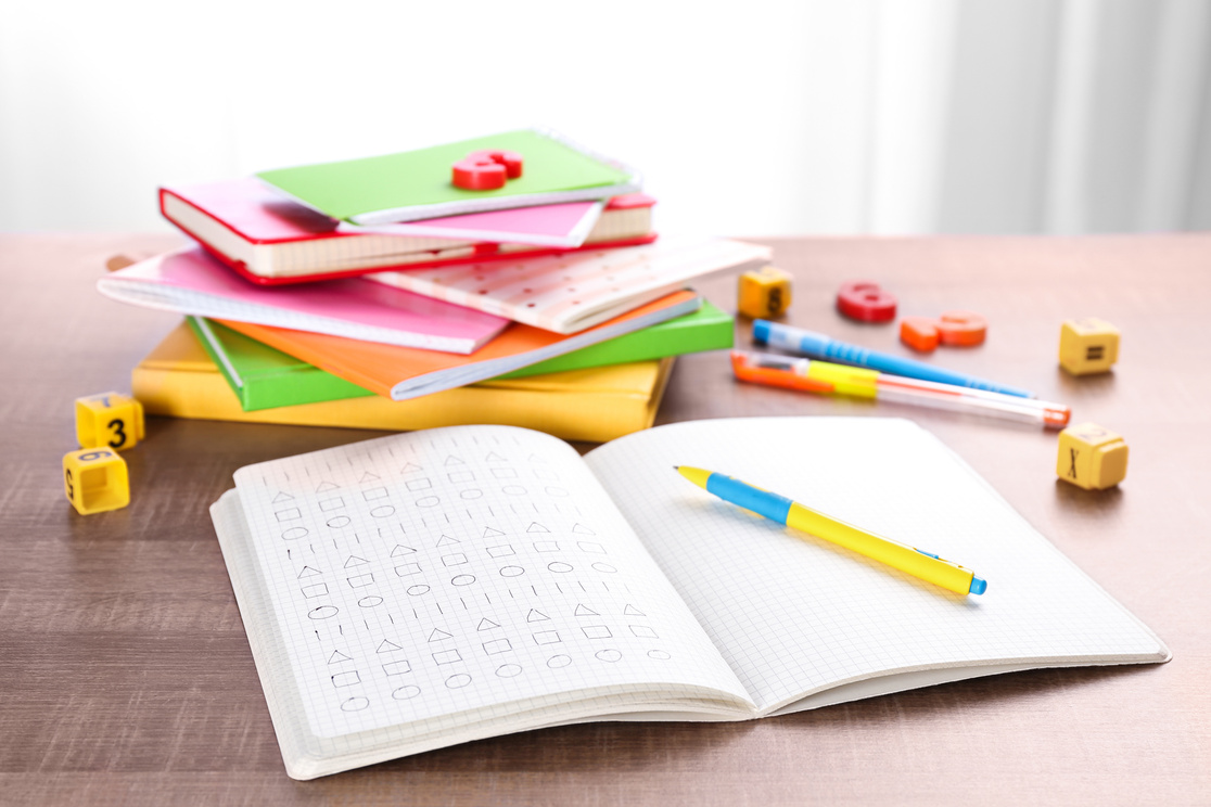 Pile of Exercise Books and Homework on Table